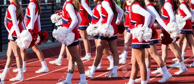 High school cheerleaders perfoming during football game